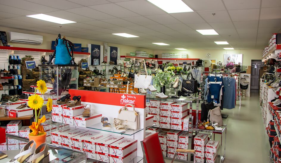 Wide shot of interior of store with shoes, boxes